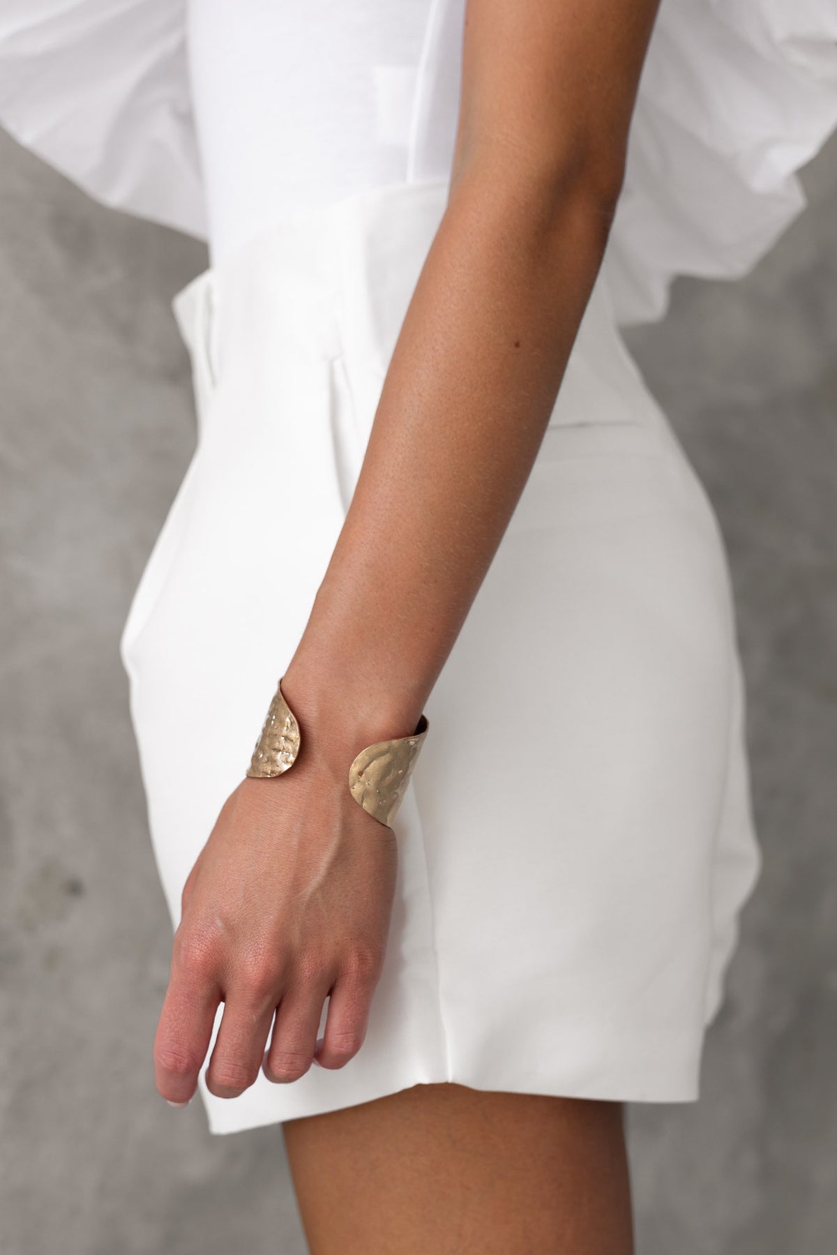 Model wearing Penelope Shorts, showcasing mid-high waist design and stylish pockets, paired with a unique bracelet.