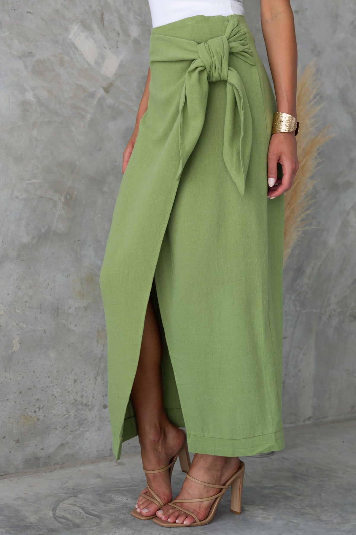 Tahnee Maxi Skirt in green, featuring a wrap look, tie at the side, and asymmetric hemline for a chic summer style.
