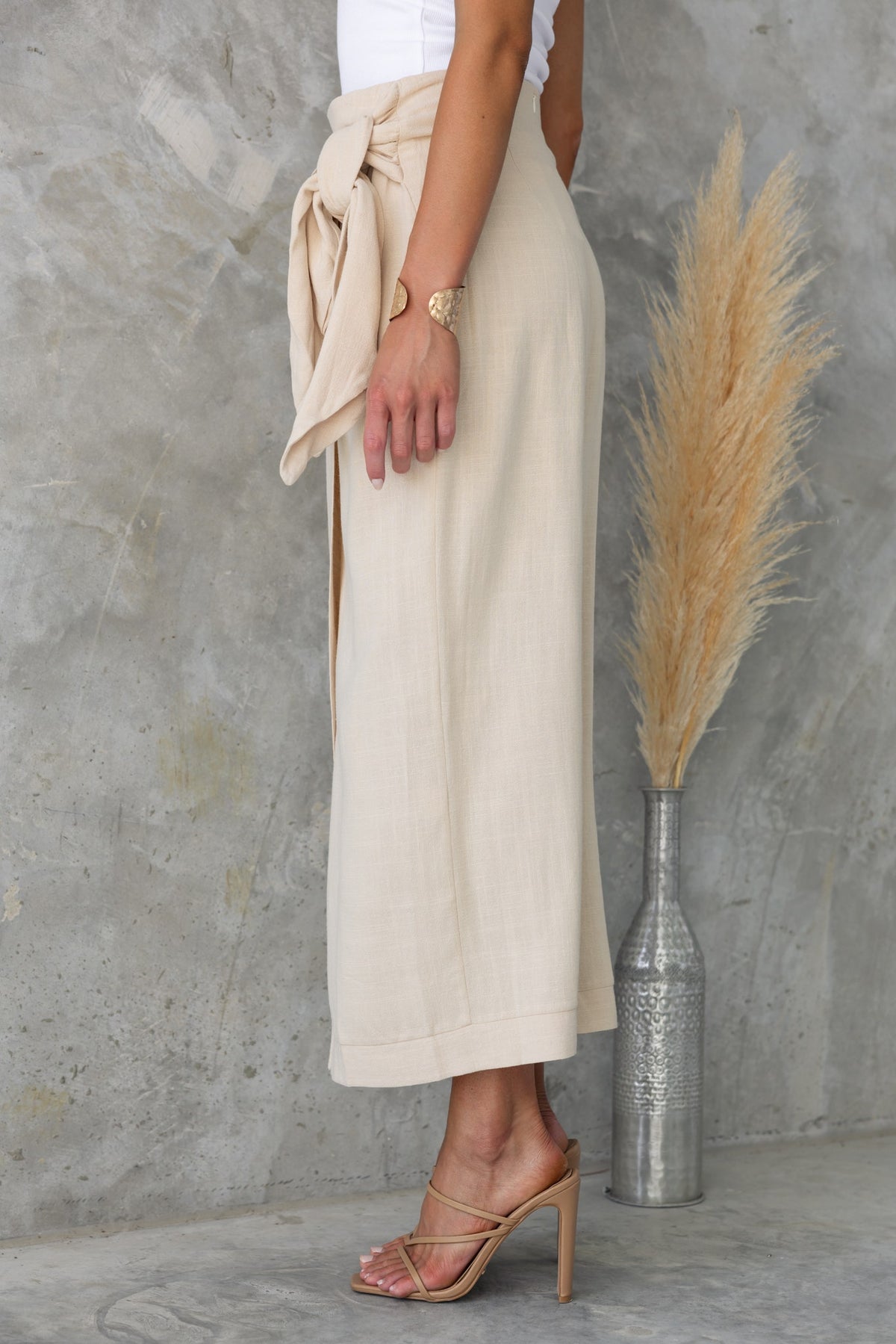Side view of the Tahnee Maxi Skirt featuring a wrap design, tie detail, and an asymmetric hemline.