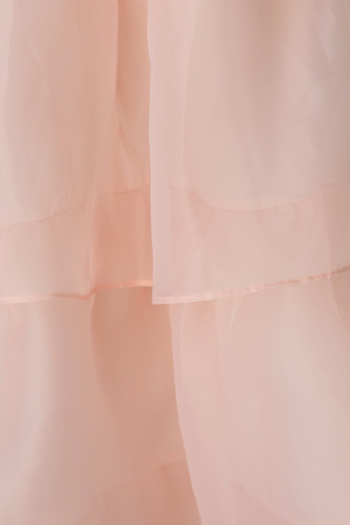 Close-up view of soft pink chiffon fabric showcasing the layered texture and flow of the Lilianna Maxi Dress.