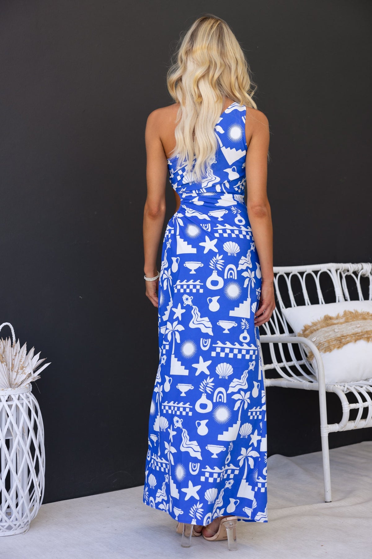 Back view of Merinda Maxi Dress featuring an abstract print in blue, one-shoulder style and elastic cut-out design.