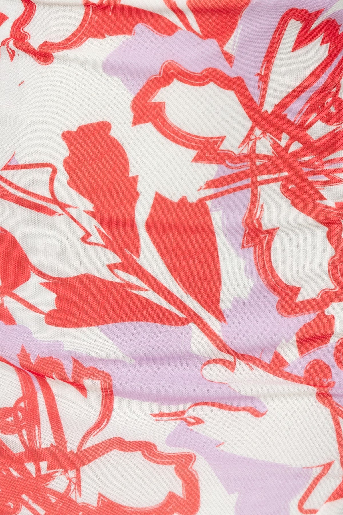 Floral print fabric in vibrant red and lavender hues, featuring a decorative flower pattern on soft material.