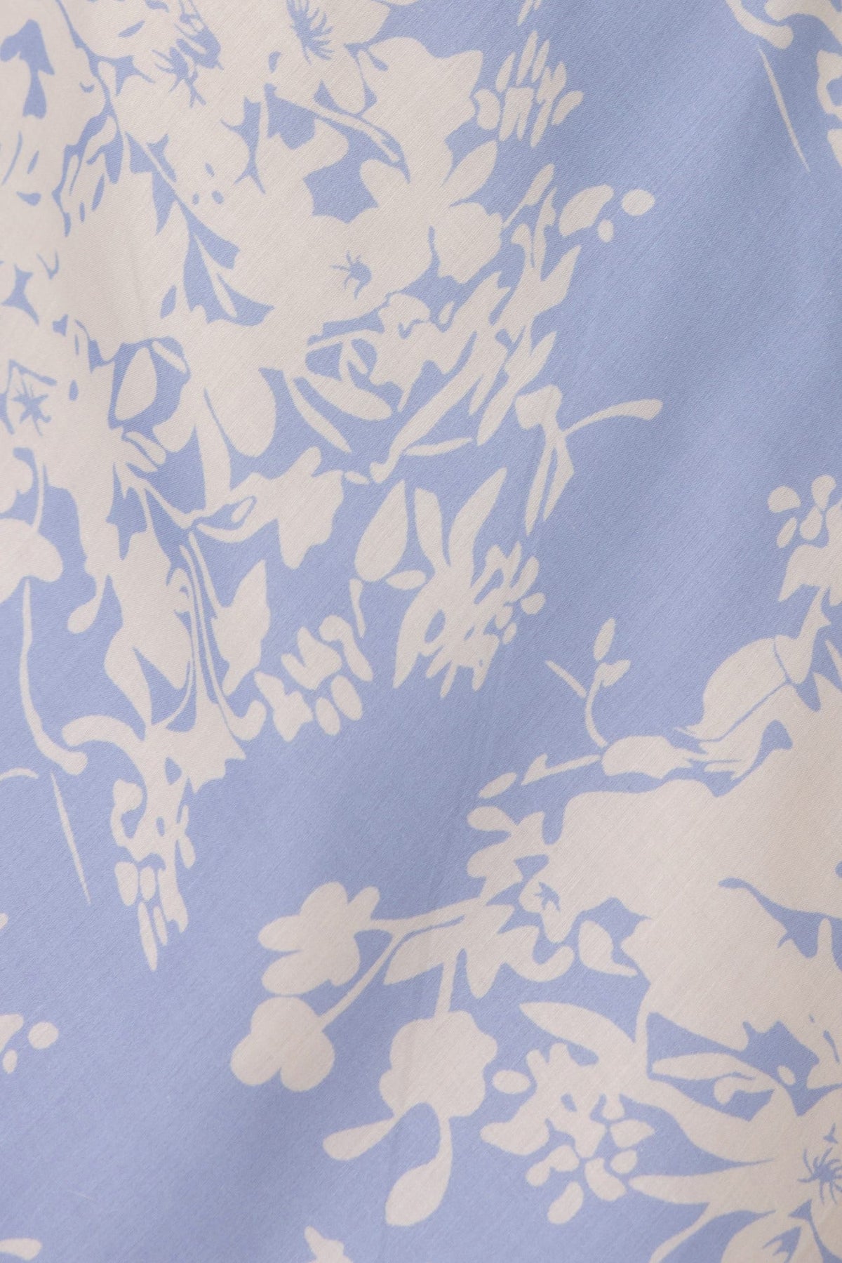 Floral print fabric in blue and white, featuring delicate flowers for a lightweight and airy look.