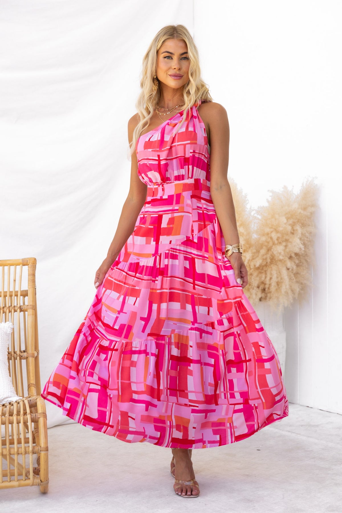 Model wearing a vibrant Tovah Maxi Dress featuring a one-shoulder neckline and a colorful abstract pattern.