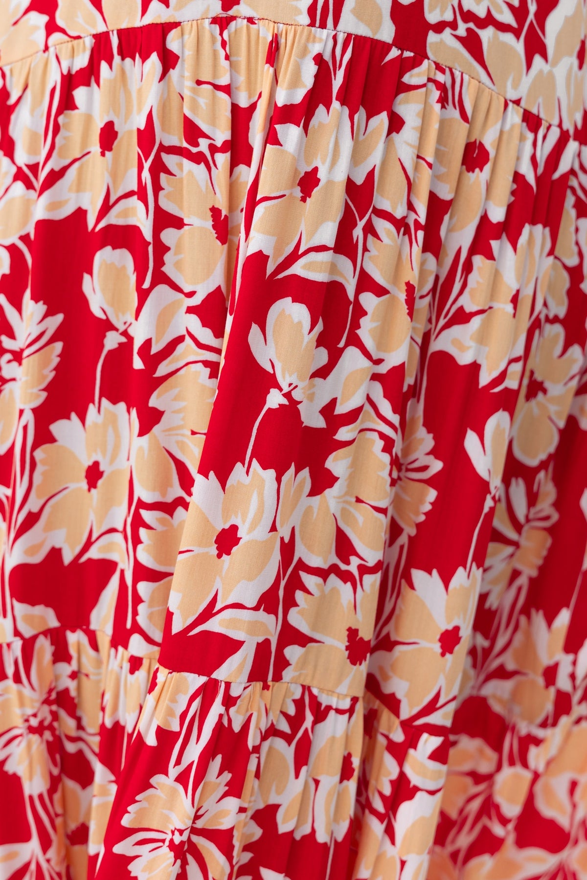 Floral print detail of the Vani Maxi Dress featuring red and yellow flowers on a light material.