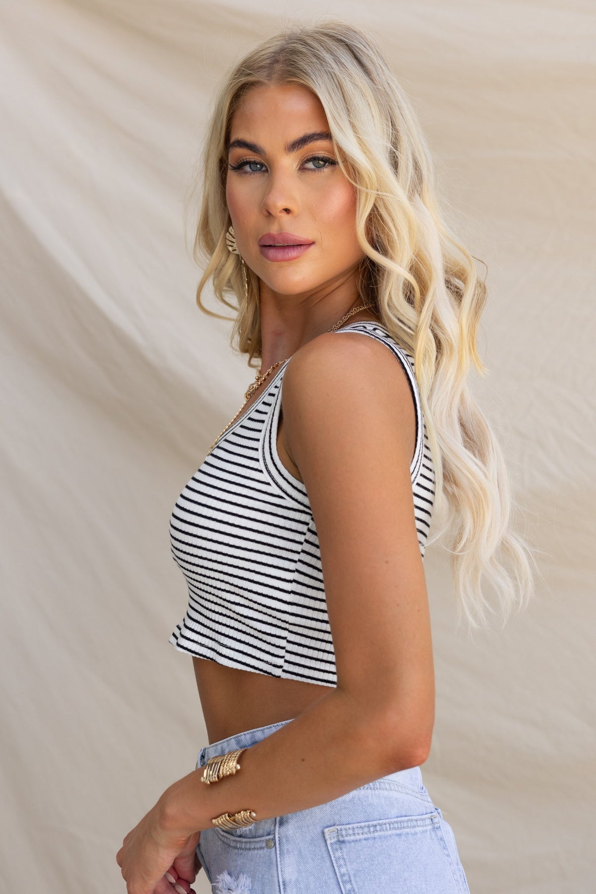 Model wearing the Reo Top, a striped crop top with a round neckline and ribbed material.