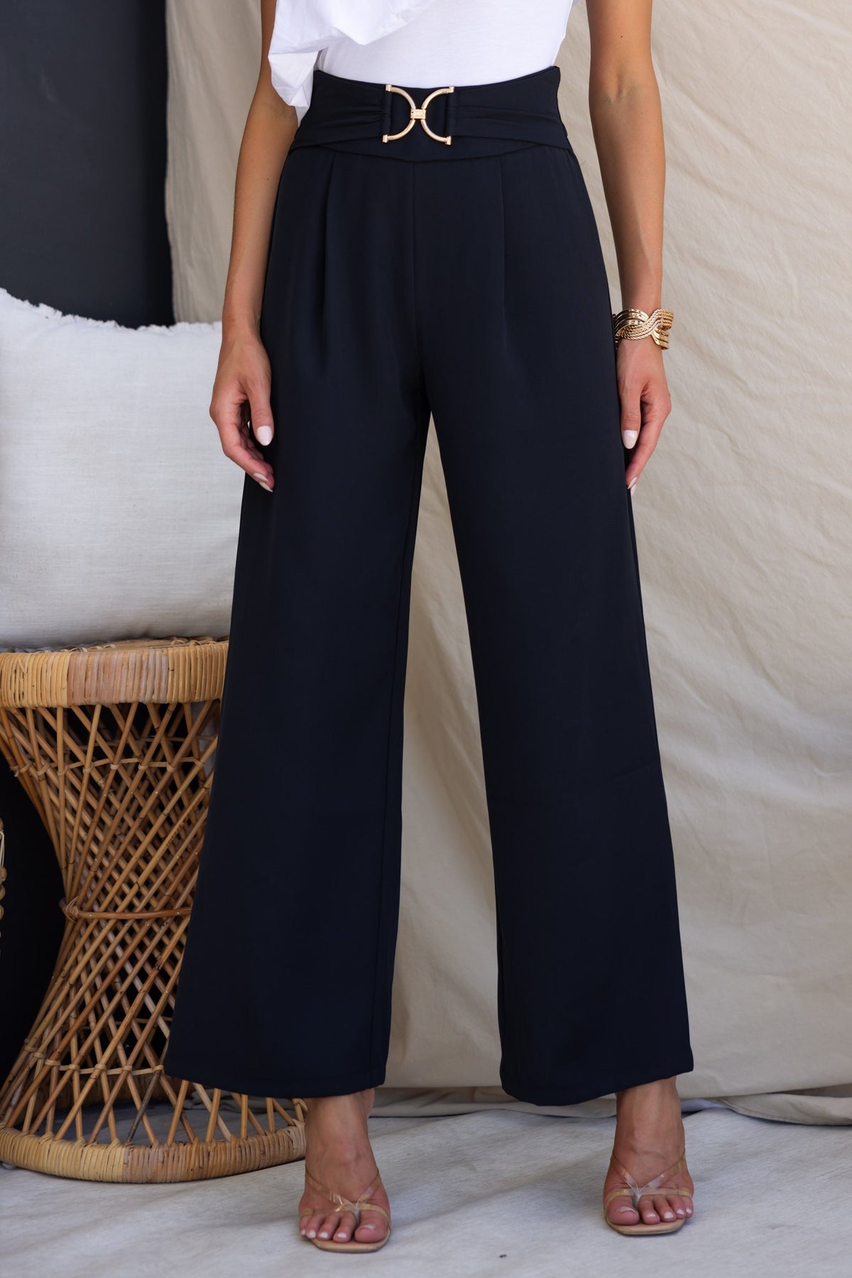 Lianna Pants in black with mid-high waist, gold buckle detail, and a wide-leg fit, perfect for elegant looks.