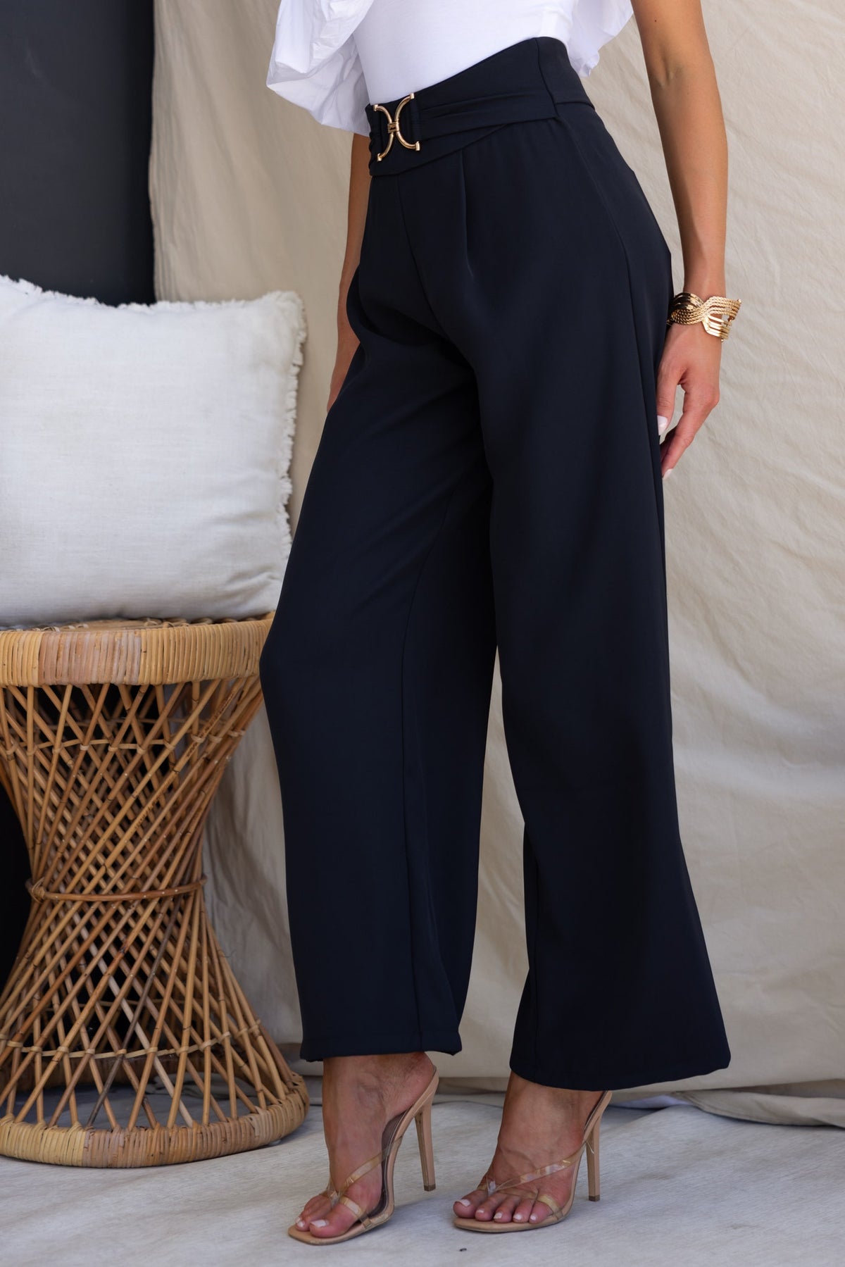 Stylish Lianna pants in black with mid-high waist, gold buckle detail, perfect for a chic outfit.