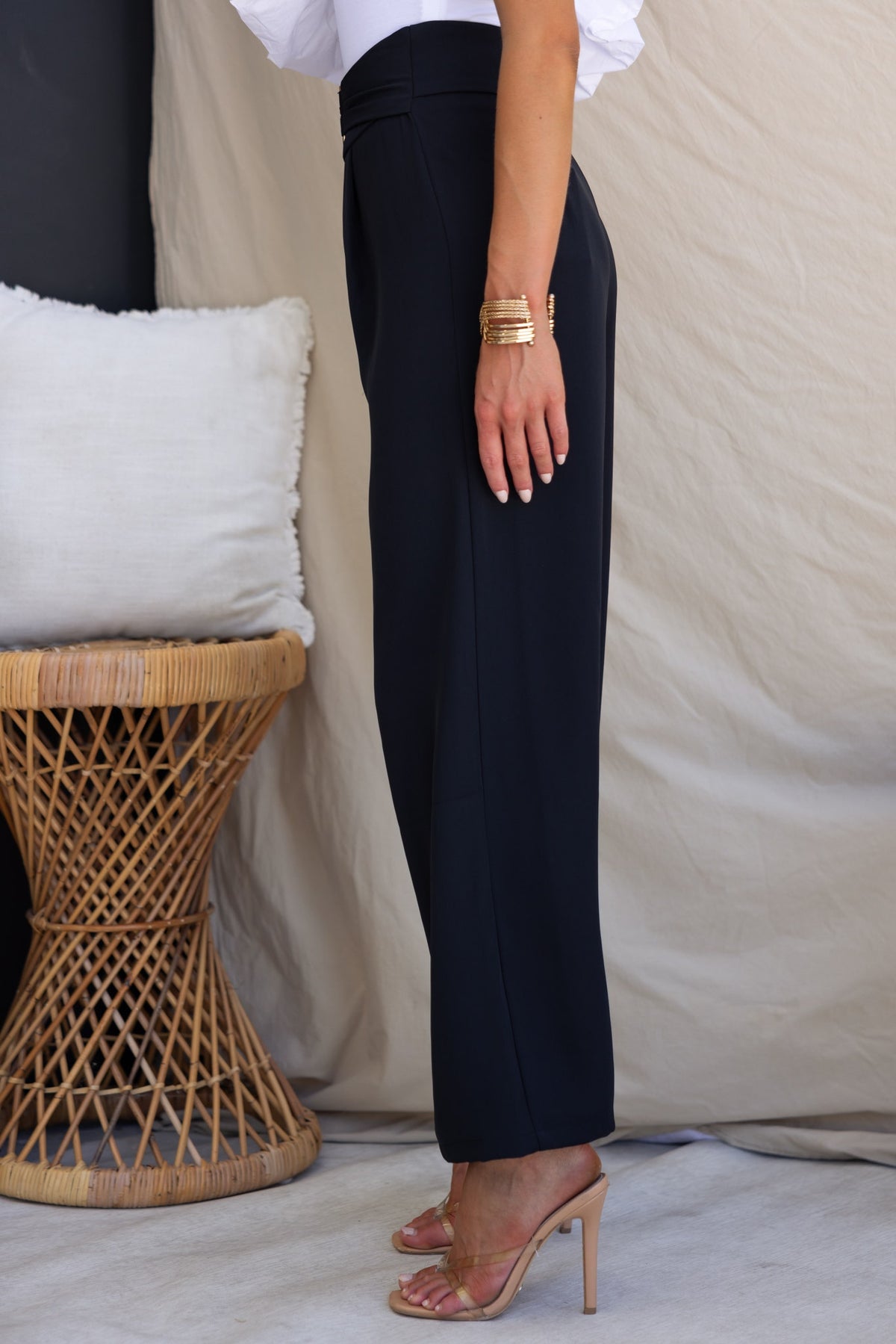 Side view of Lianna Pants, black dress pants with a mid-high waist and buckle detail, styled with a chic top.
