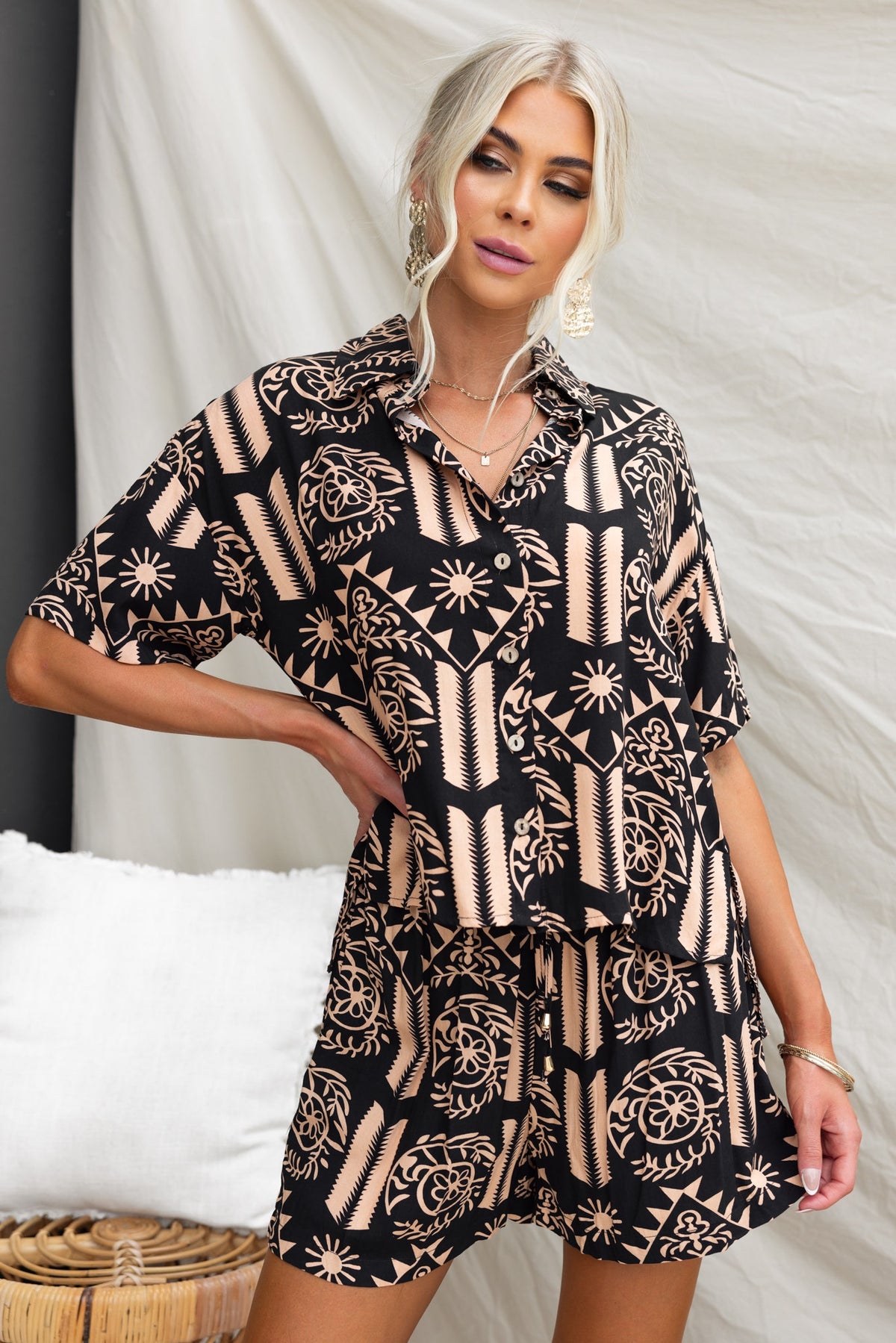 Model wearing stylish black and beige patterned ginger shorts with relaxed fit and short-sleeve shirt.