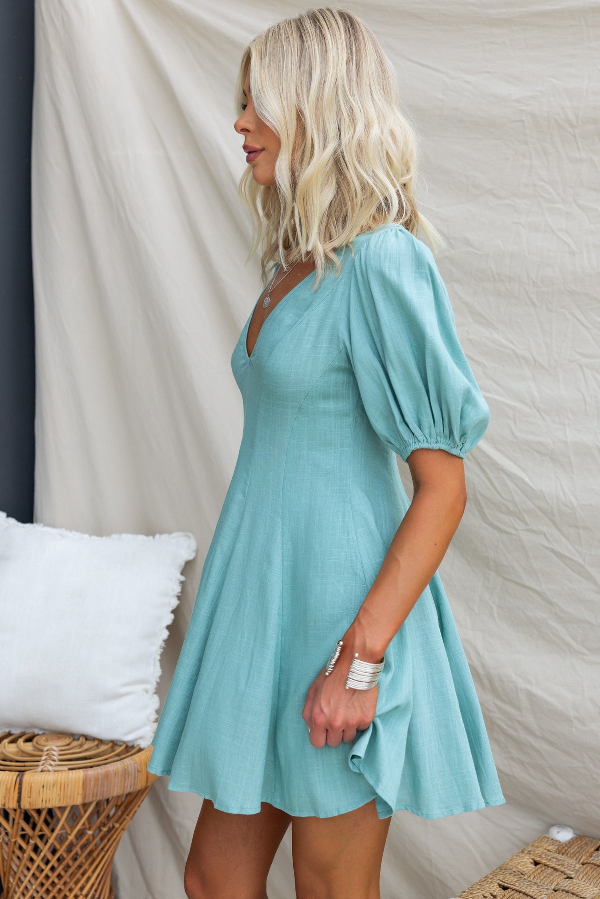 Model wearing a light blue V-neck dress with puff sleeves, showcasing a casual and relaxed fit.