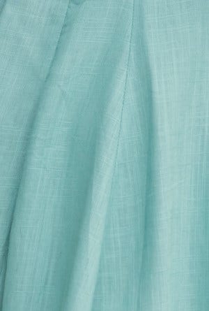 Close-up of soft aqua fabric showcasing the linen texture and drape perfect for casual wear in warm weather.