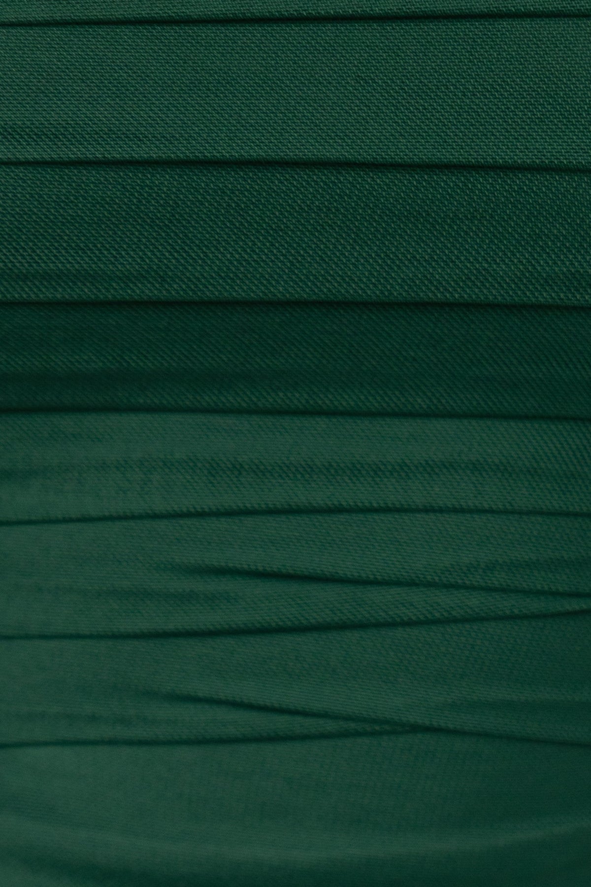 Close-up of textured green mesh fabric with ruching, showcasing the elegant design of the Eldora Dress.