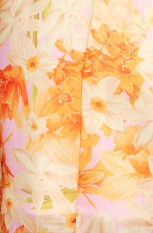 Close-up of floral pattern featuring orange and white flowers on a pink background, ideal for a vibrant dress design.