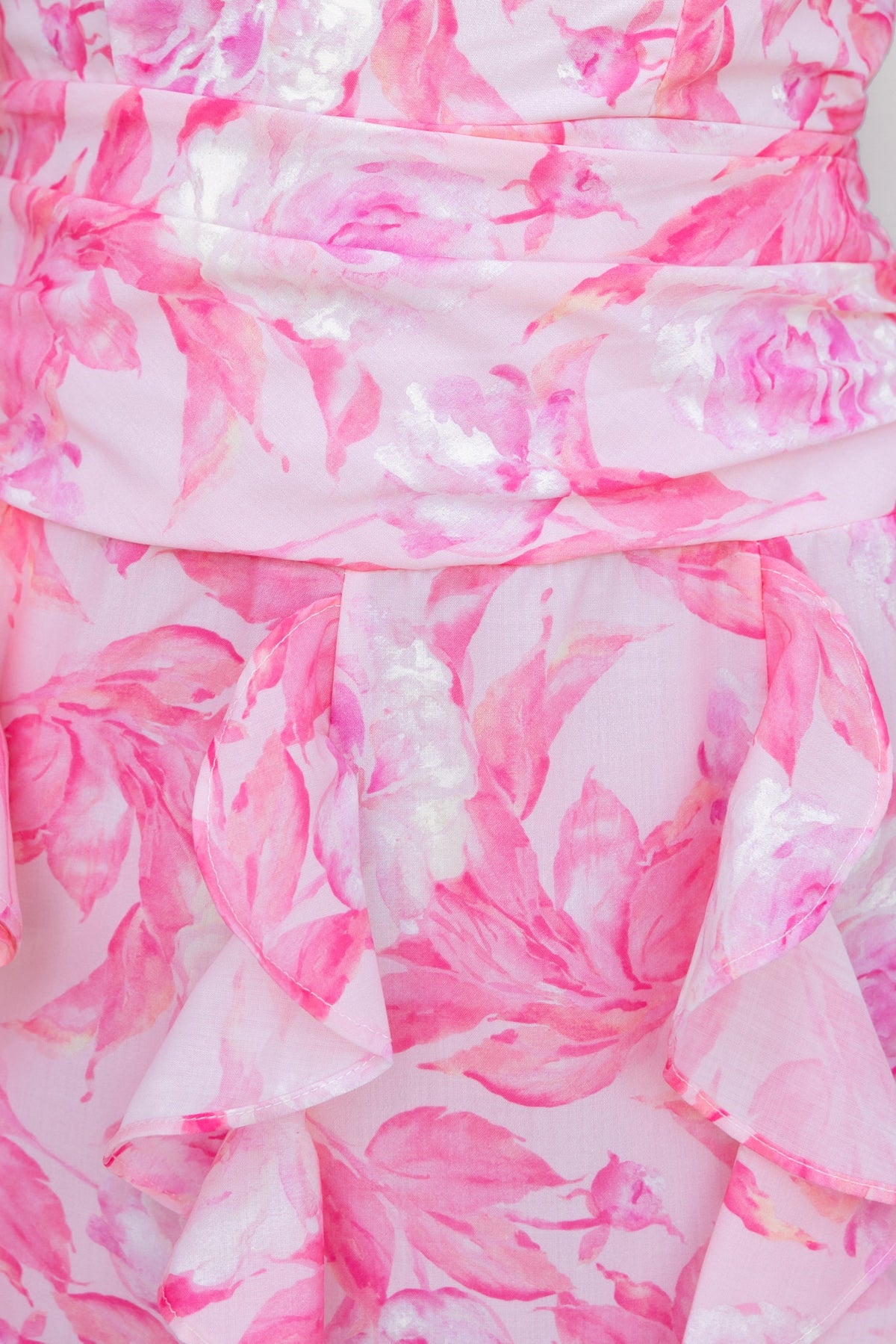 Close-up of Genovia Maxi Dress with pink floral fabric and ruffled detailing, showcasing floral print and smooth texture.
