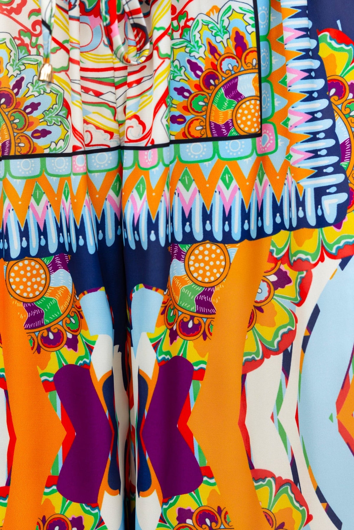 Vibrant abstract print featuring colorful floral and geometric patterns on a fabric.
