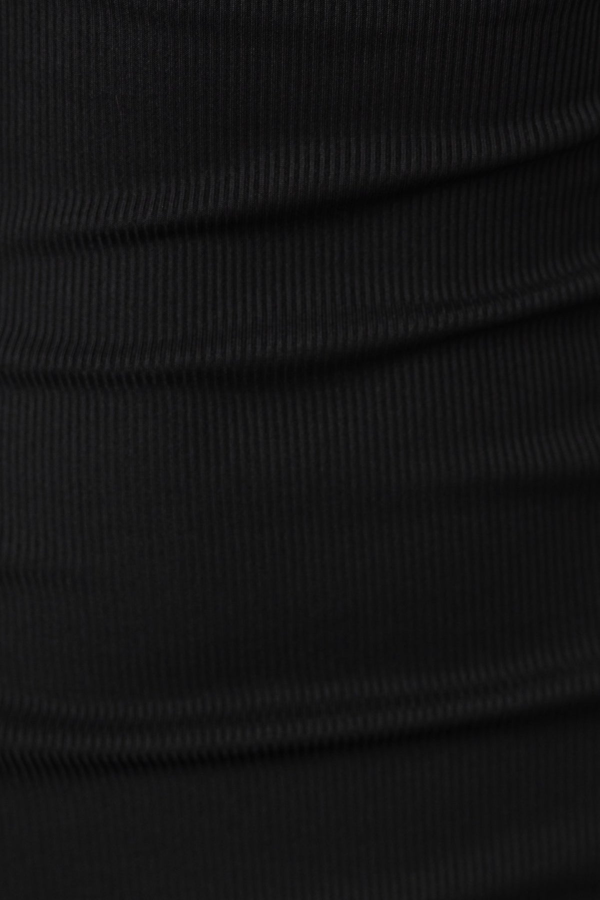 Close-up of ribbed black fabric showcasing texture and stretch for Magee Dress.