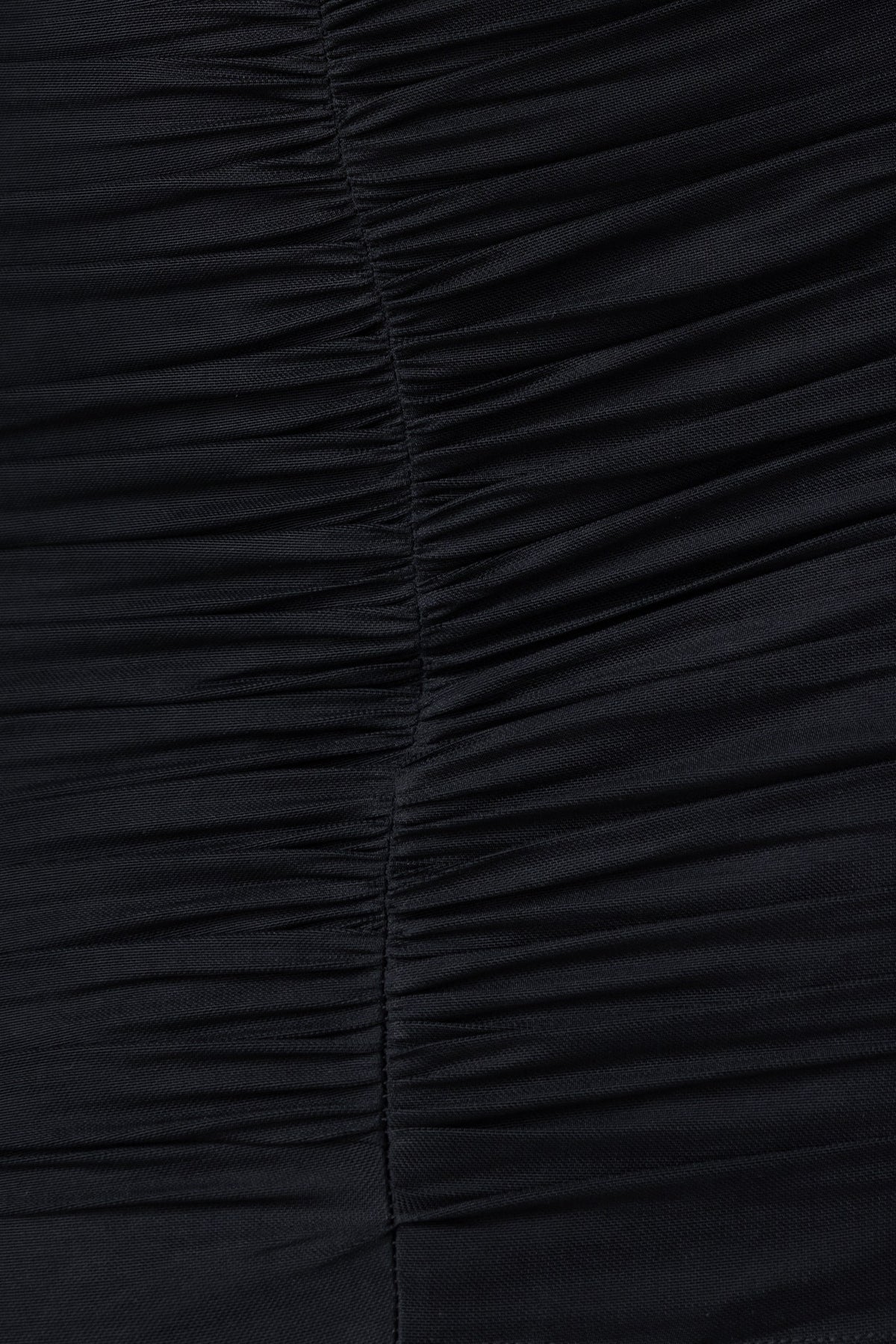 Detail of the Torrey Dress in black, showcasing ruching and soft mesh material for added elegance.