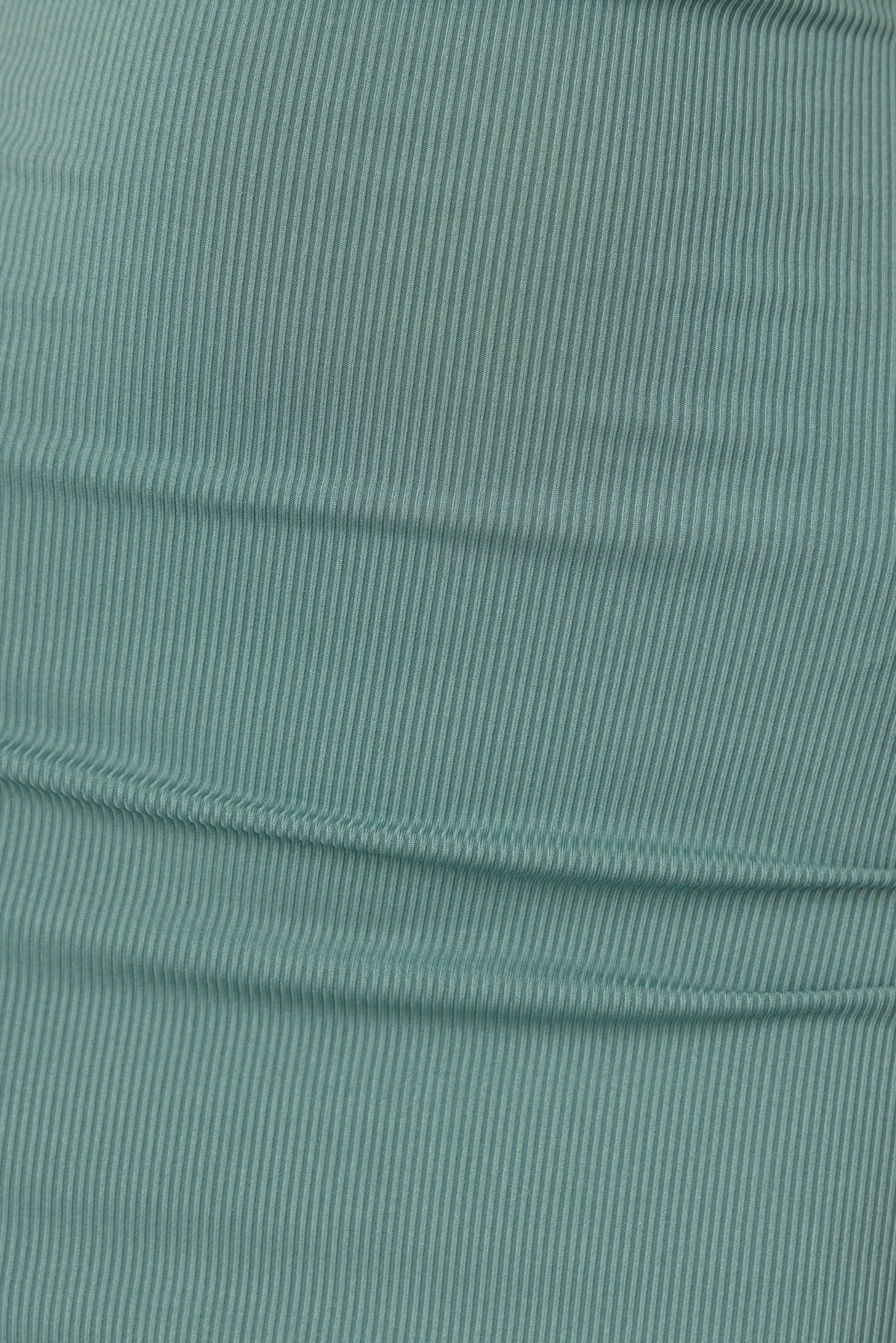 Close-up of ribbed turquoise fabric showcasing the texture and stretch of the material used in the Magee Dress.
