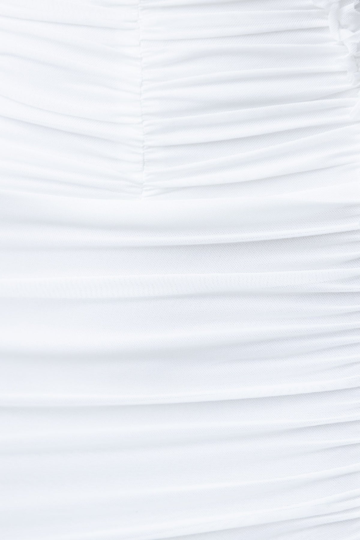Close-up of white ruched fabric, showcasing the texture and stretch of the material.