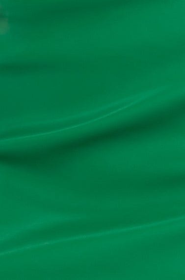 Close-up of a rich green faux leather fabric, showcasing its smooth texture and luxurious sheen.