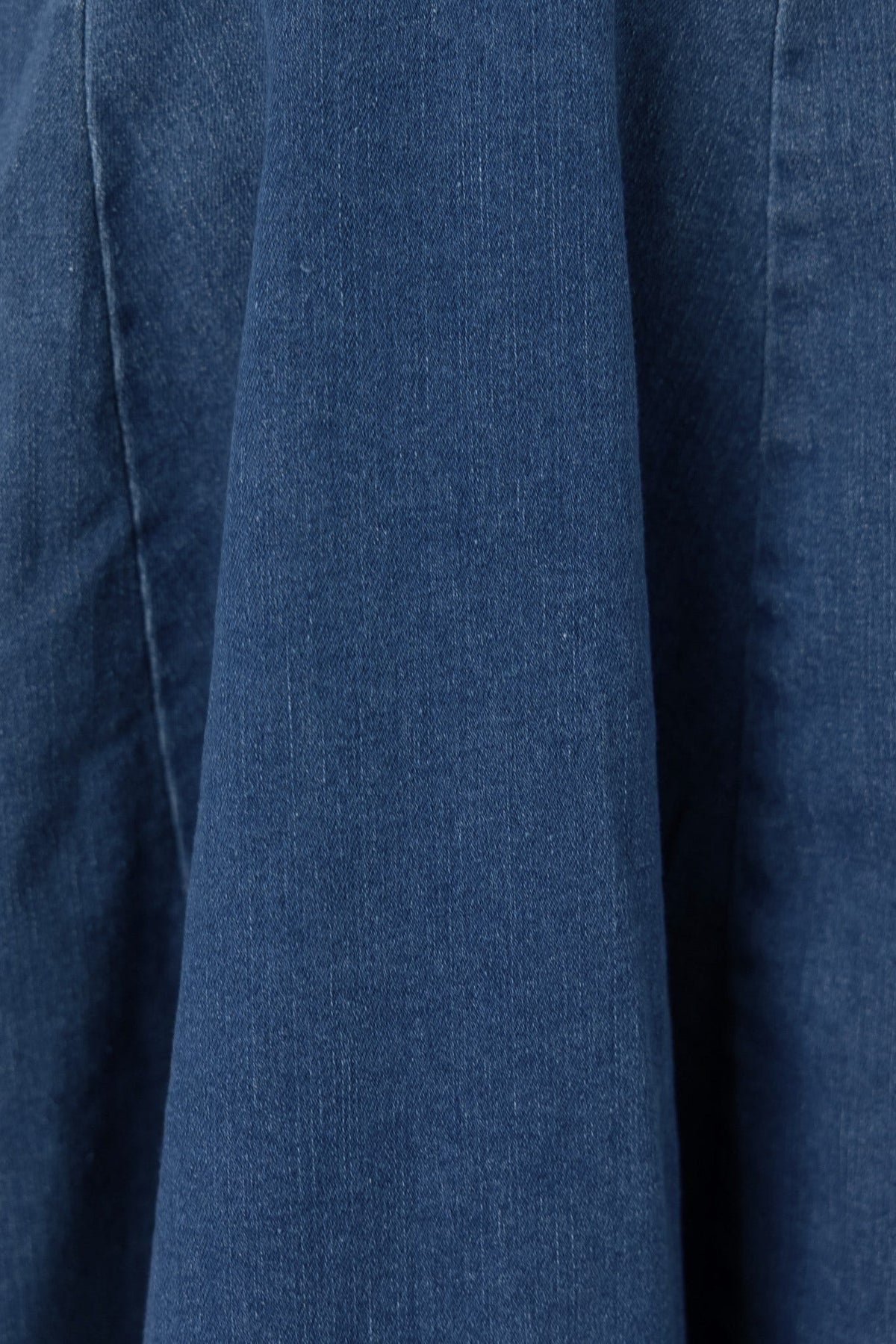 Close-up of the fabric texture of a Natty Denim Dress, showcasing the rich blue denim and its flexible composition.