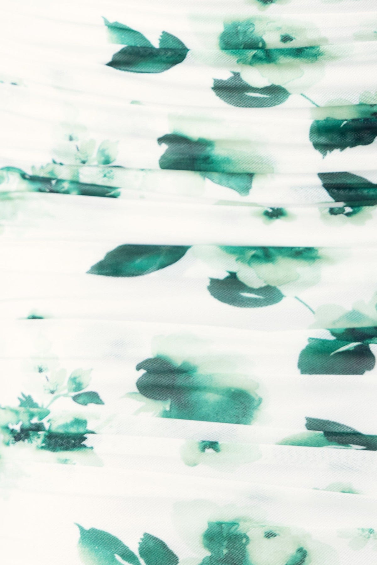 Close-up of Harland Dress fabric featuring green floral print on stretchy mesh overlay.