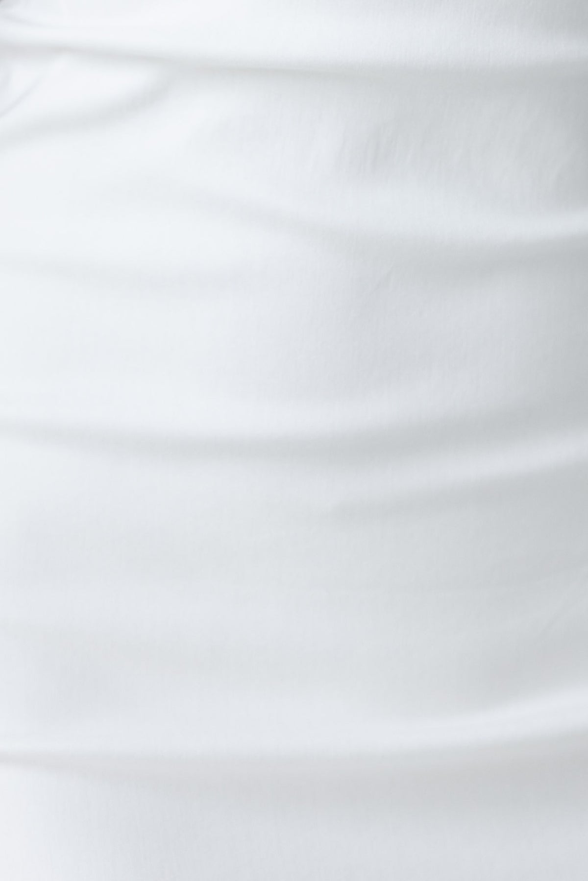 Close-up of the soft white fabric of the Bunni Dress, showcasing its stretchy material and smooth texture.