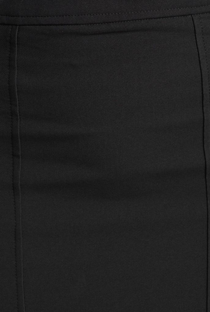 Close-up of a black fabric skirt with smooth texture and visible stitching details.
