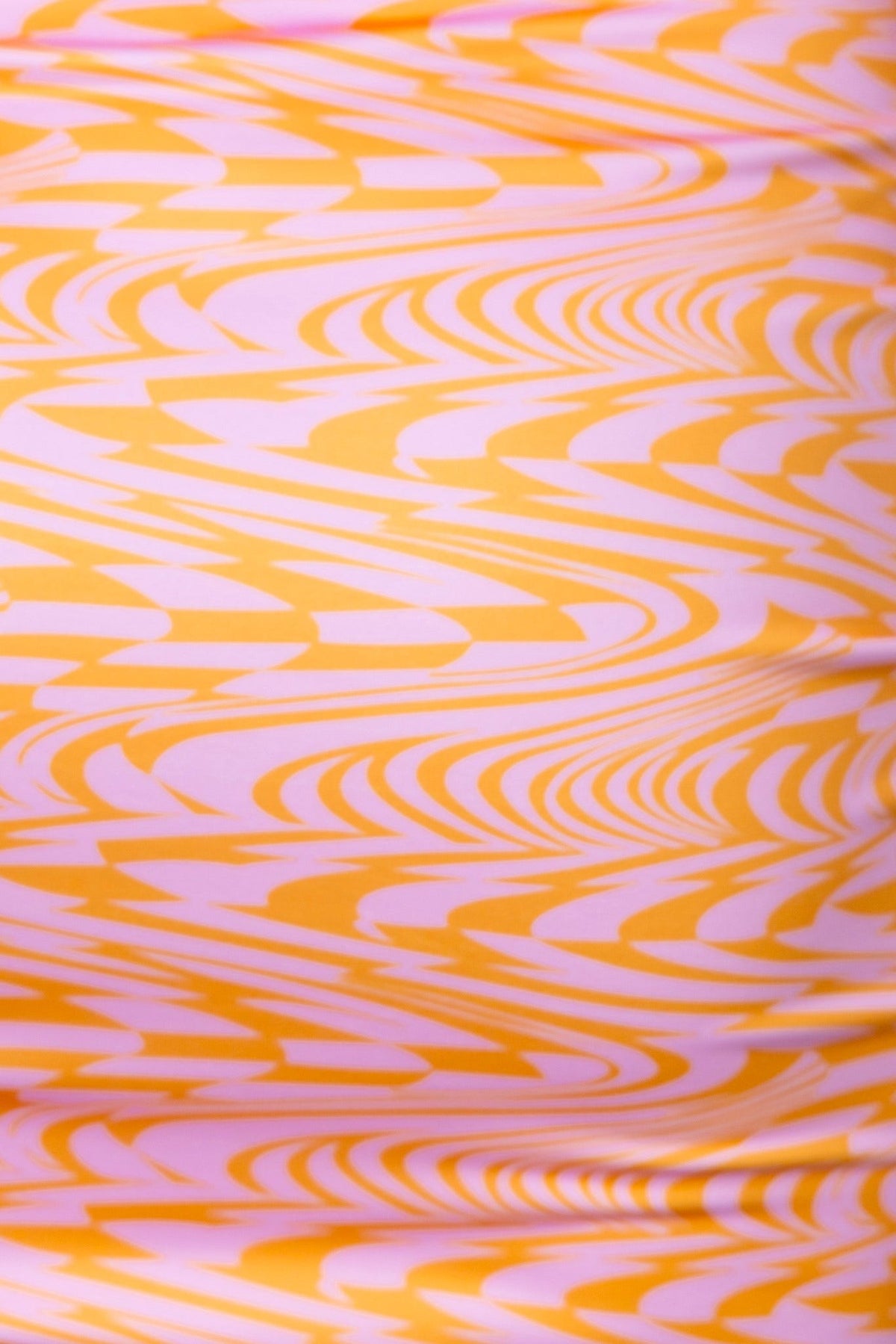 Close-up of vibrant orange and pink swirled fabric pattern, ideal for apparel like dresses.