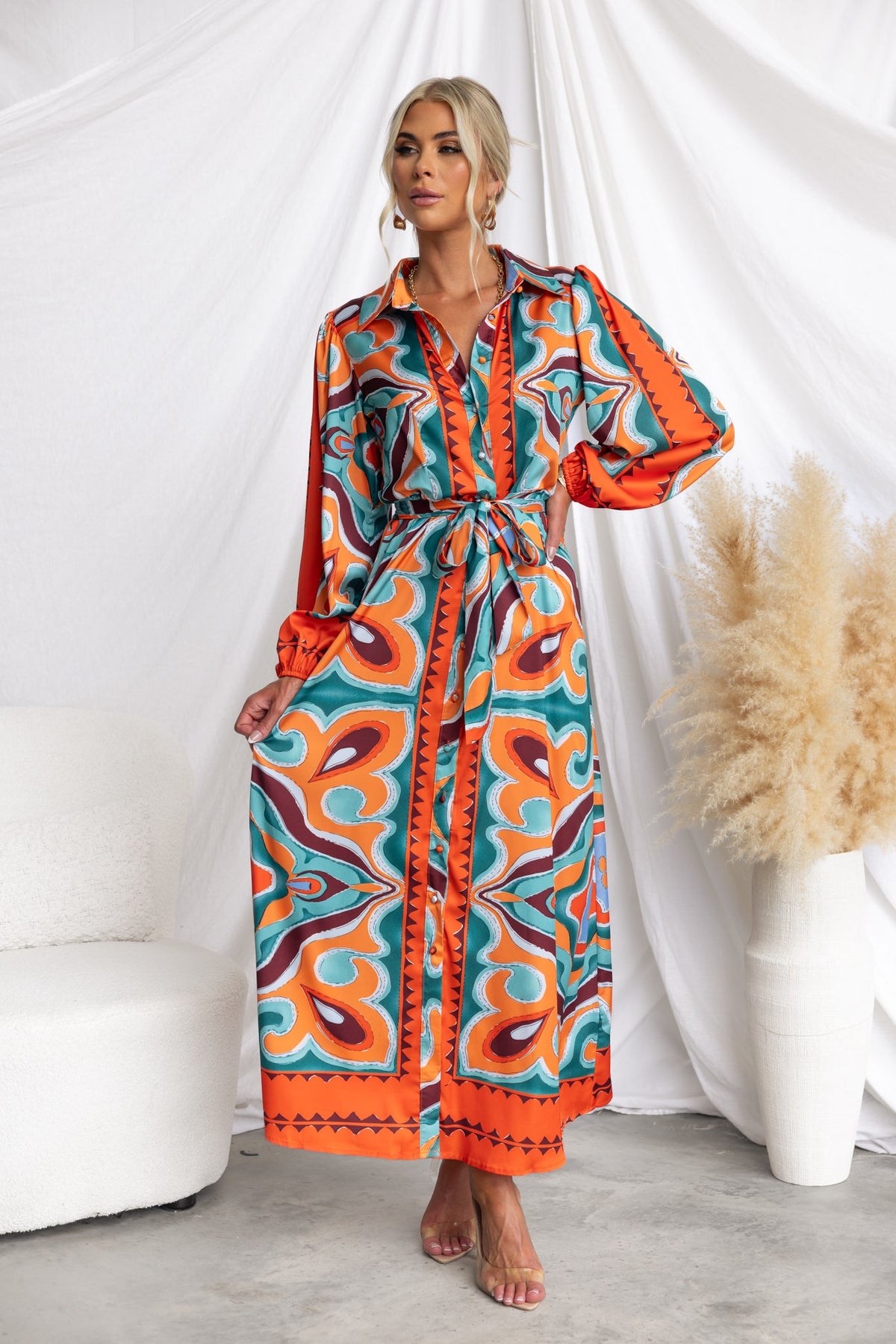 Namari Maxi Dress with abstract print, button-up front, elastic sleeves, and removable tie, styled in vibrant colors.