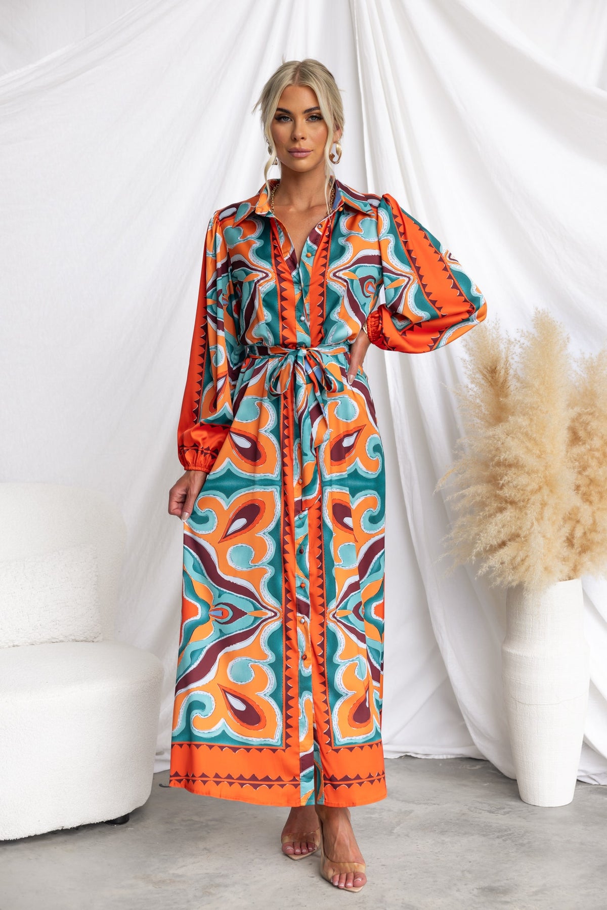 Model wearing a Namari Maxi Dress featuring an abstract print, button-up front, and removable fabric tie.