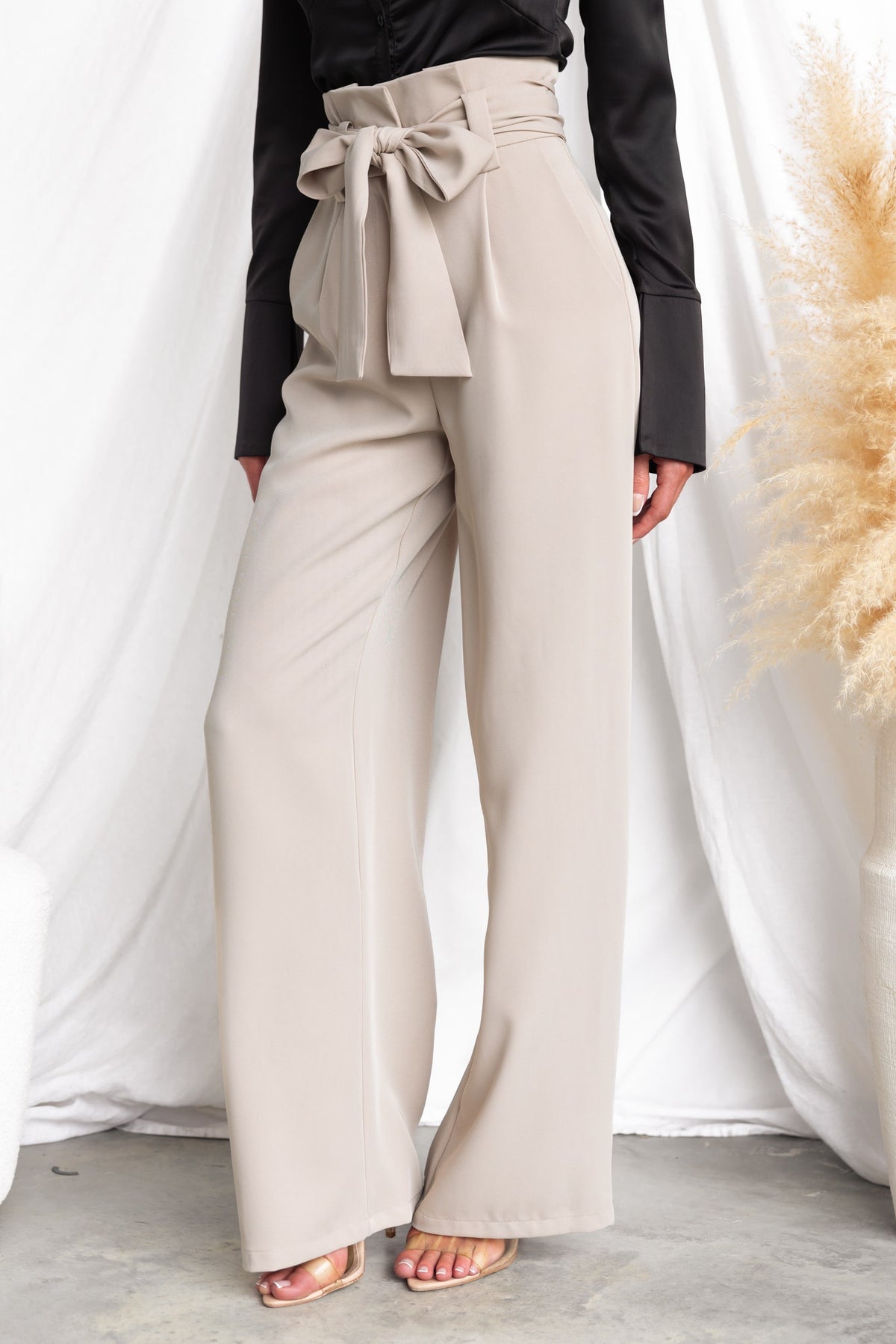 Jaspin Pants featuring a paper bag waist, removable tie, and wide legs, styled with a black top.