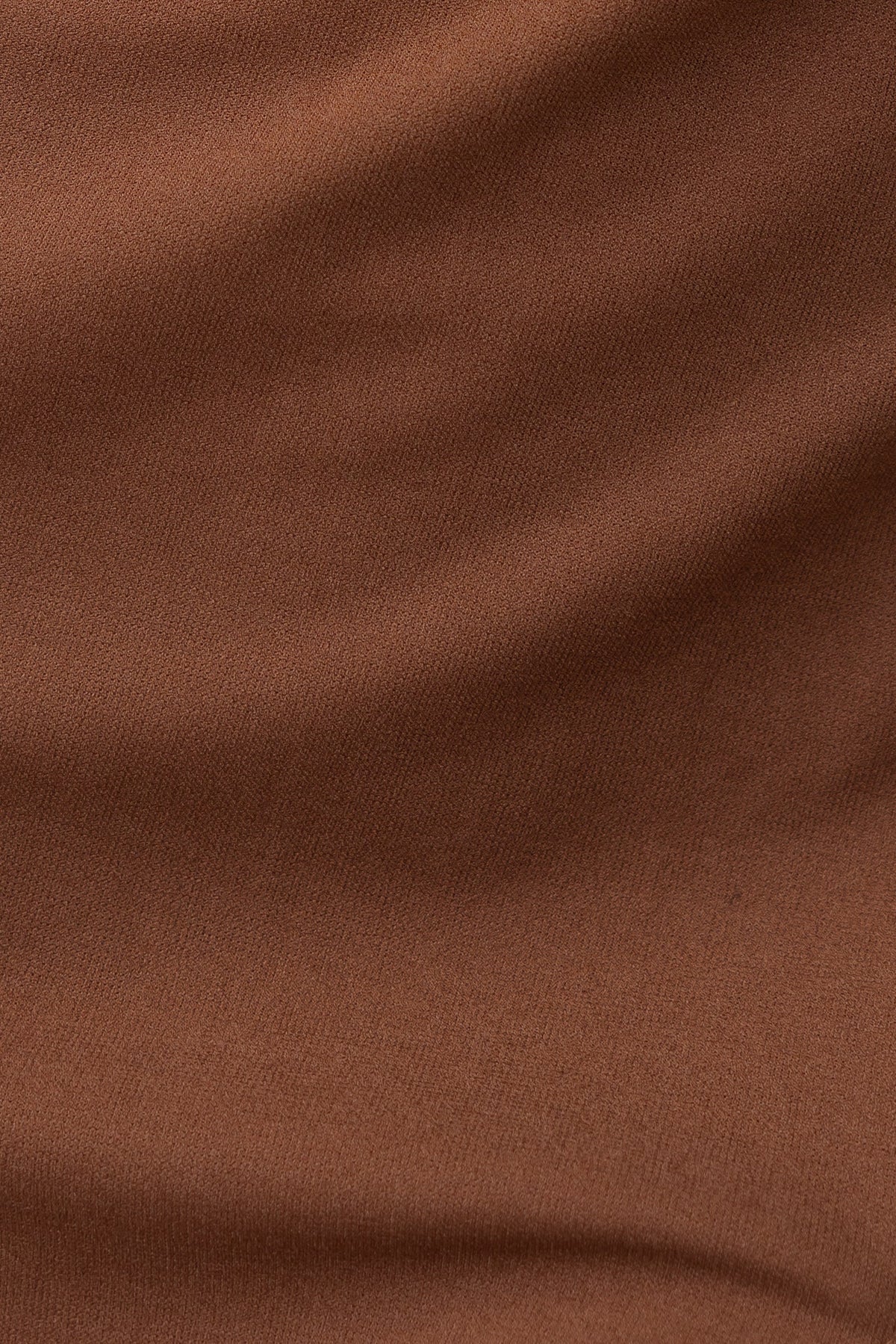 Close-up of soft, brown crepe fabric with a smooth texture, ideal for stylish dress designs.