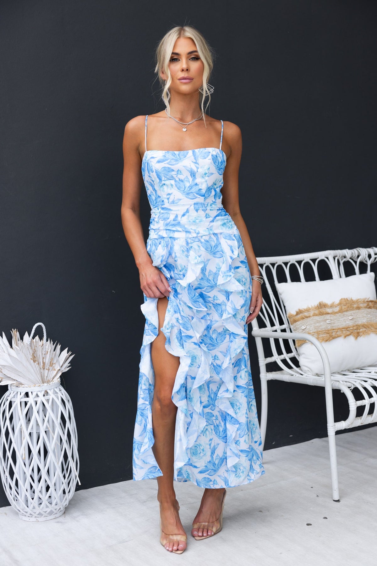 Model wearing the Genovia Maxi Dress, a blue floral dress with adjustable straps and side split.