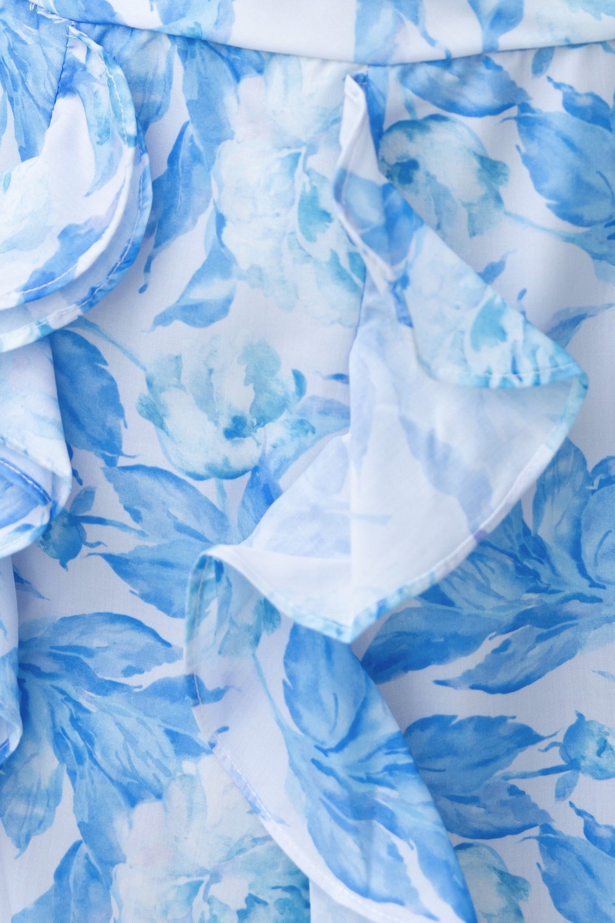 Close-up of blue floral pattern on the Genovia Maxi Dress, featuring ruffles and soft fabric.