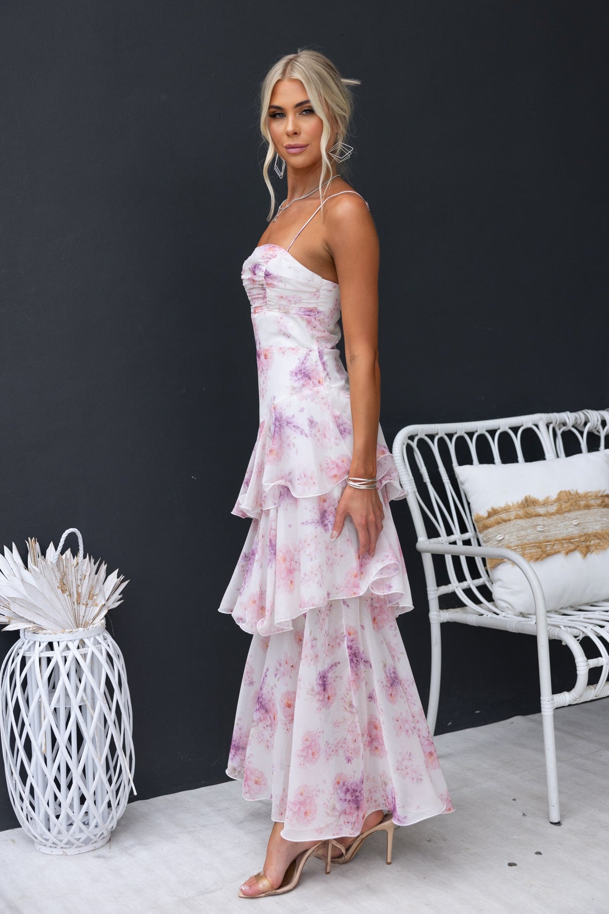 Model showcasing the Saphina Maxi Dress, a floral chiffon maxi with adjustable straps and multi-tier ruffle skirt.