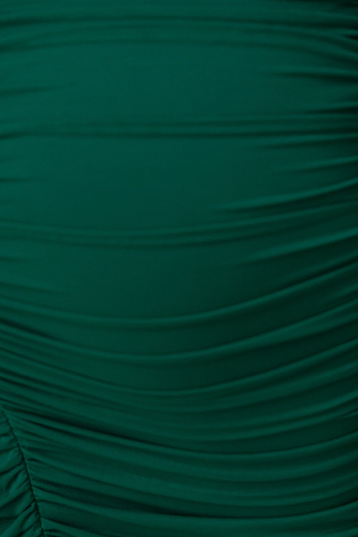 Close-up of green mesh material with ruched details from the Dorado dress, showcasing its texture and style.