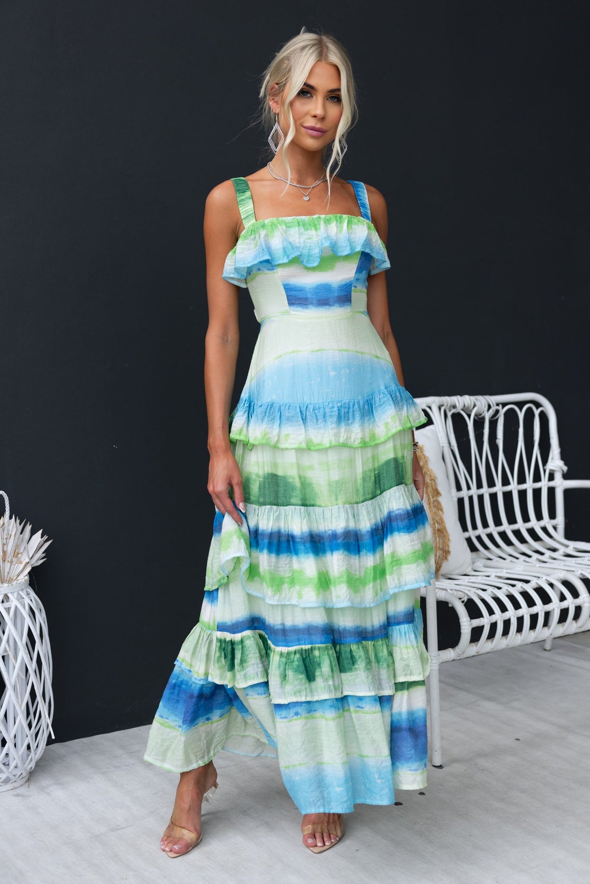 Fondar Maxi Dress featuring green and blue ruffles, elastic straps, and a flowing skirt on a model in a stylish setting.