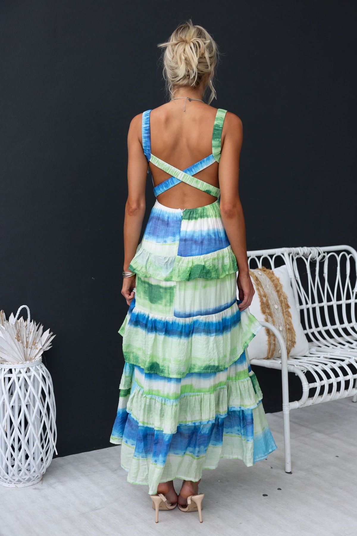 Back view of Fondar Maxi Dress featuring colorful stripes, ruffle details, and crossed straps, ideal for summer occasions.
