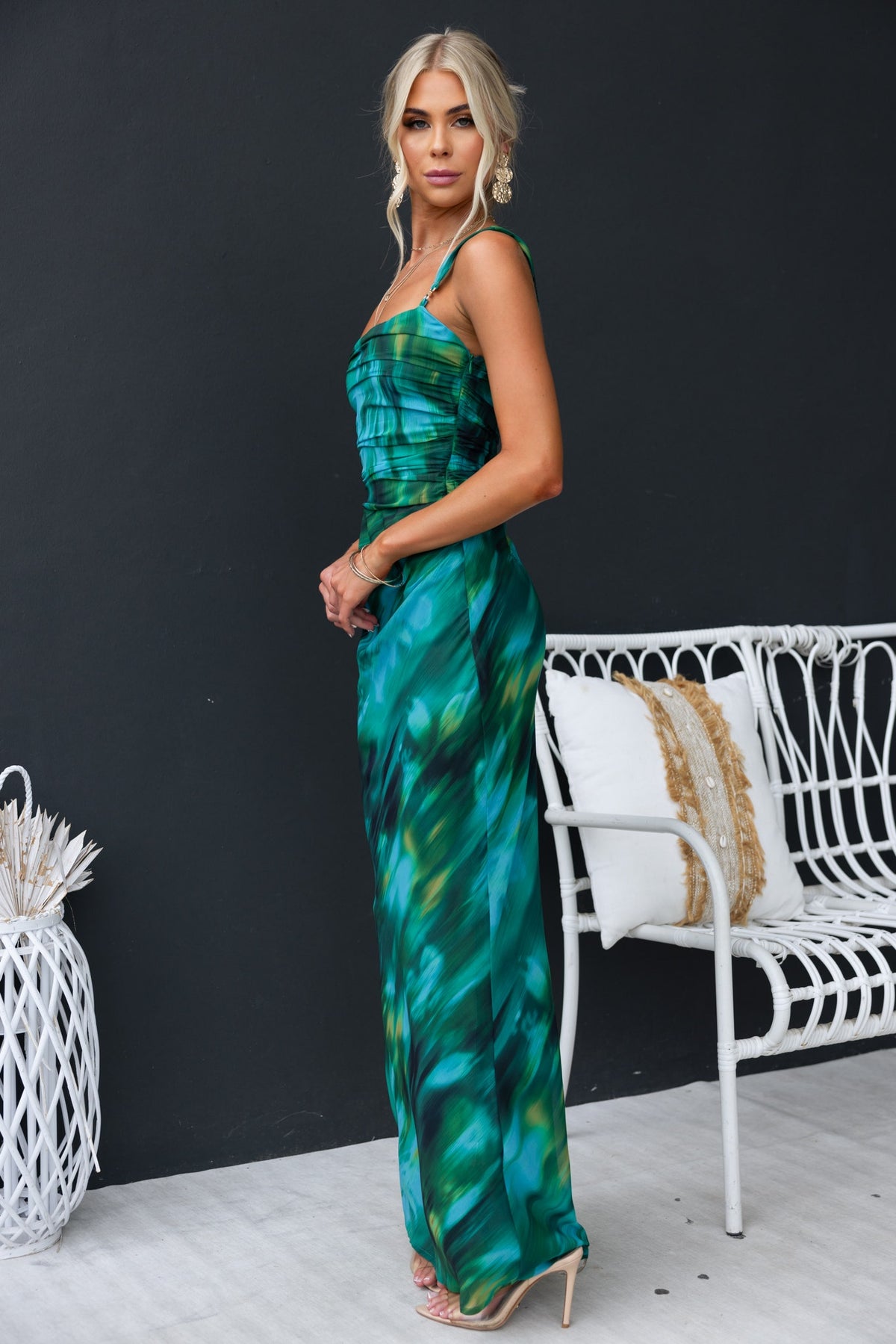 Woman in a green and blue print maxi dress with straps, showcasing a stylish design and chic look.