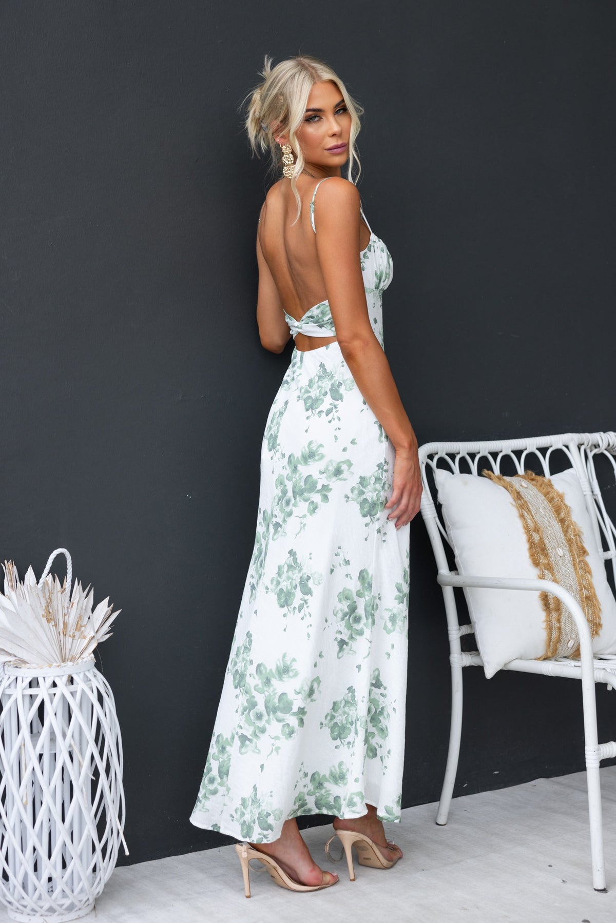 Elegant Freyda Maxi Dress featuring floral print, adjustable straps, and a stylish cut-out back, modeled by a woman.