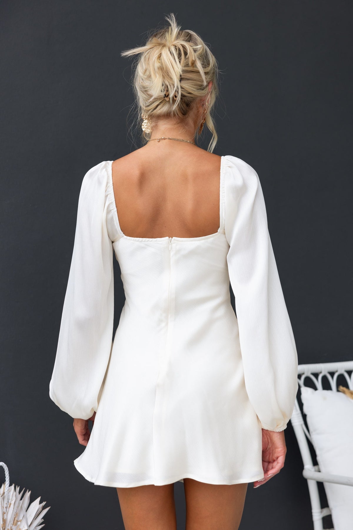 Back view of Averi Dress featuring puff sleeves, square neckline, and an invisible zip in a light fabric.