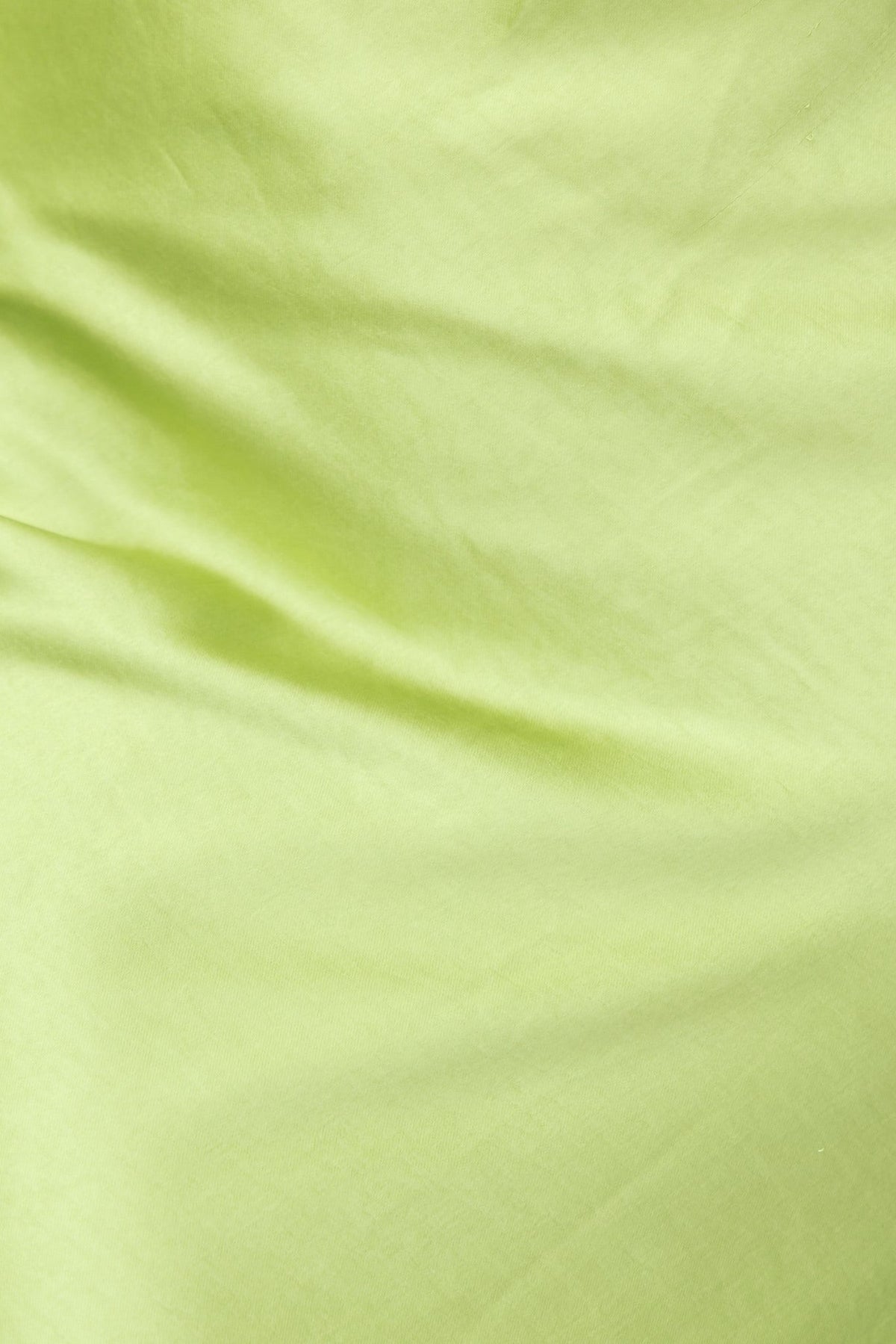 Close-up of light green satin fabric showcasing a smooth, luxurious texture, ideal for elegant garments like dresses.