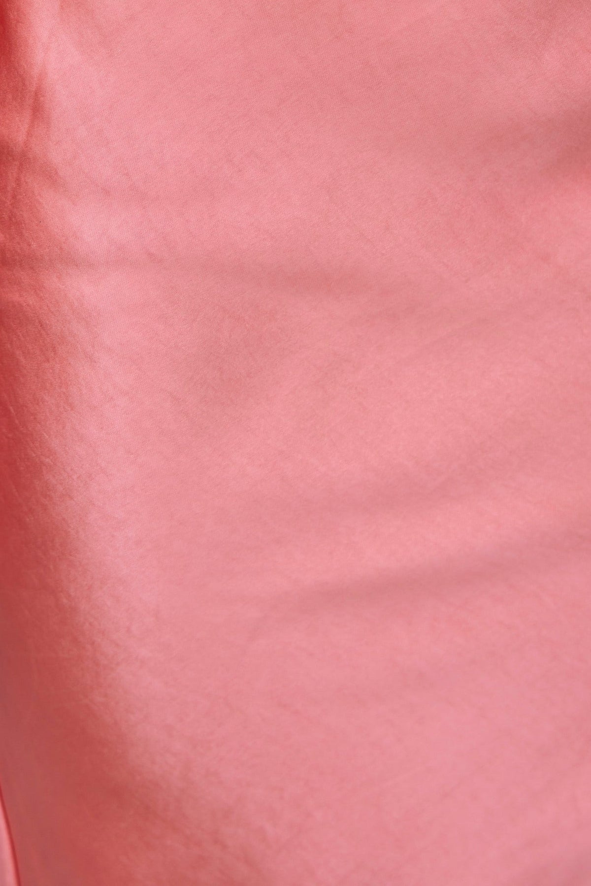 Close-up of the soft satin fabric in a blush pink shade, showcasing its smooth texture for the Jeyne Midi Dress.