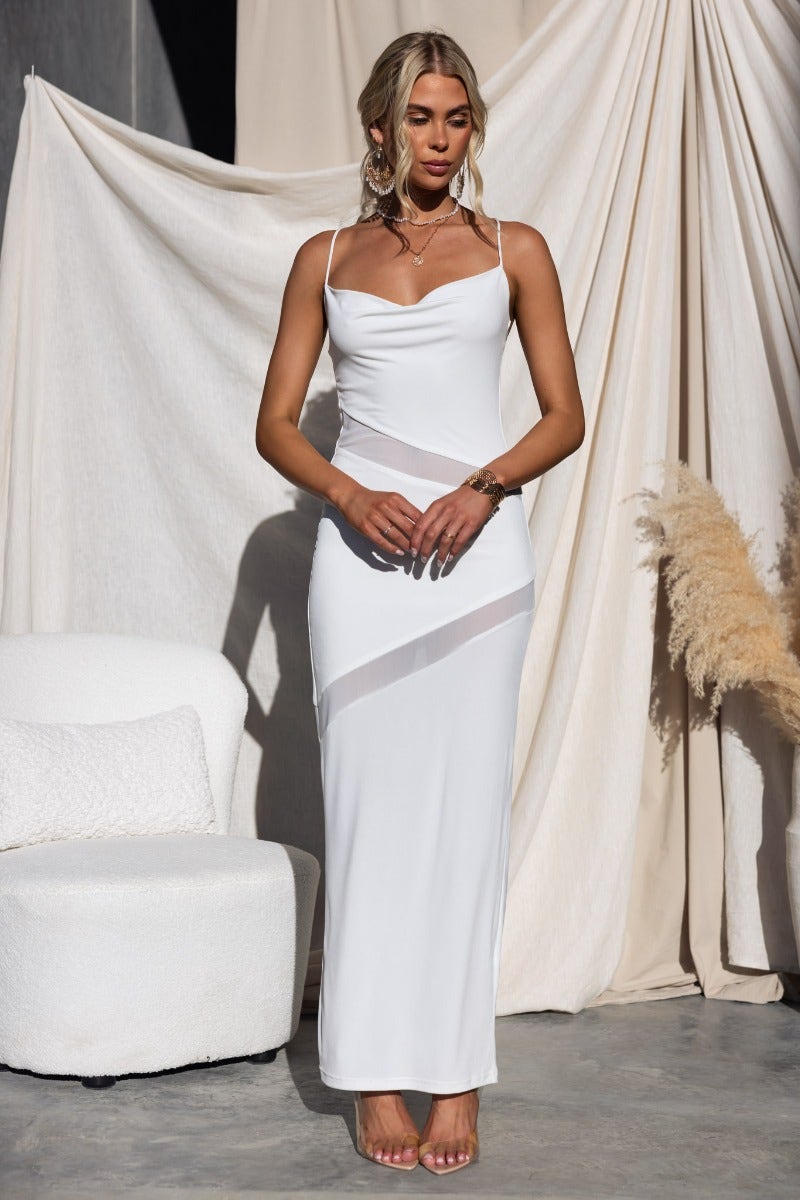 Model wearing Millard Maxi Dress with cowl neckline, sheer panels, and adjustable straps in white.