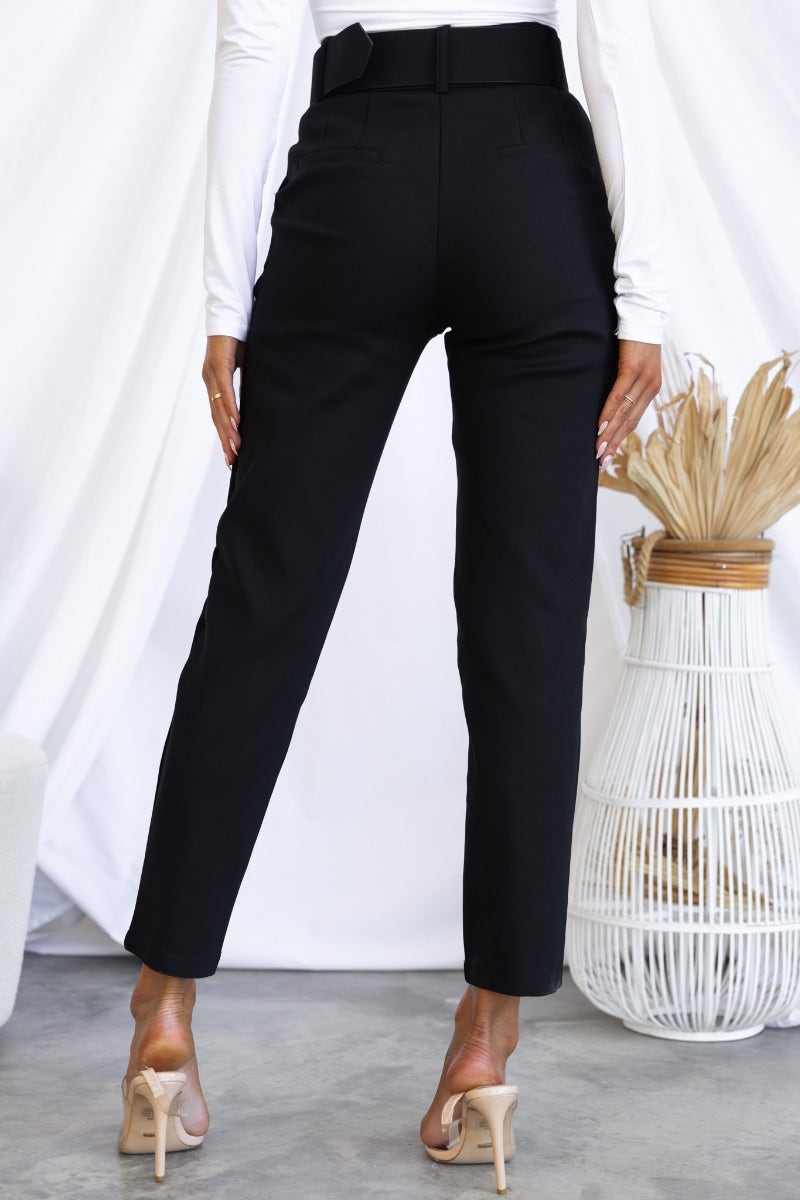 Back view of Kaniva black dress pants with removable belt, slim fit, styled with a white top and nude heels.