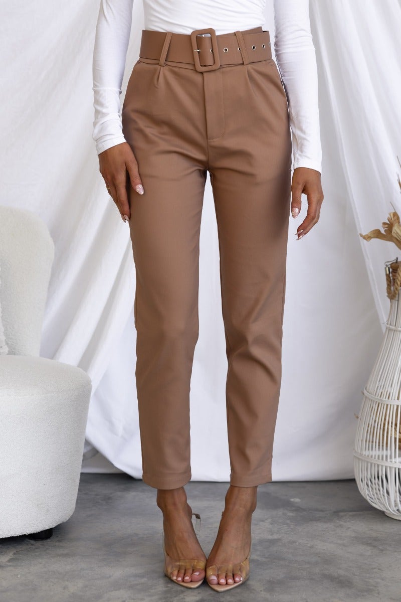 Stylish Kaniva Pants in brown with removable belt, front pockets, and slim fit on a model.