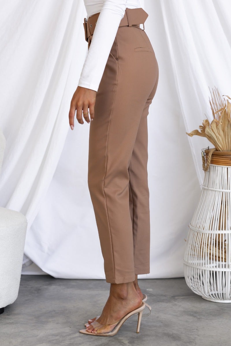 Side view of Kaniva pants in brown, featuring a removable belt and slim fit design, styled with a casual top.