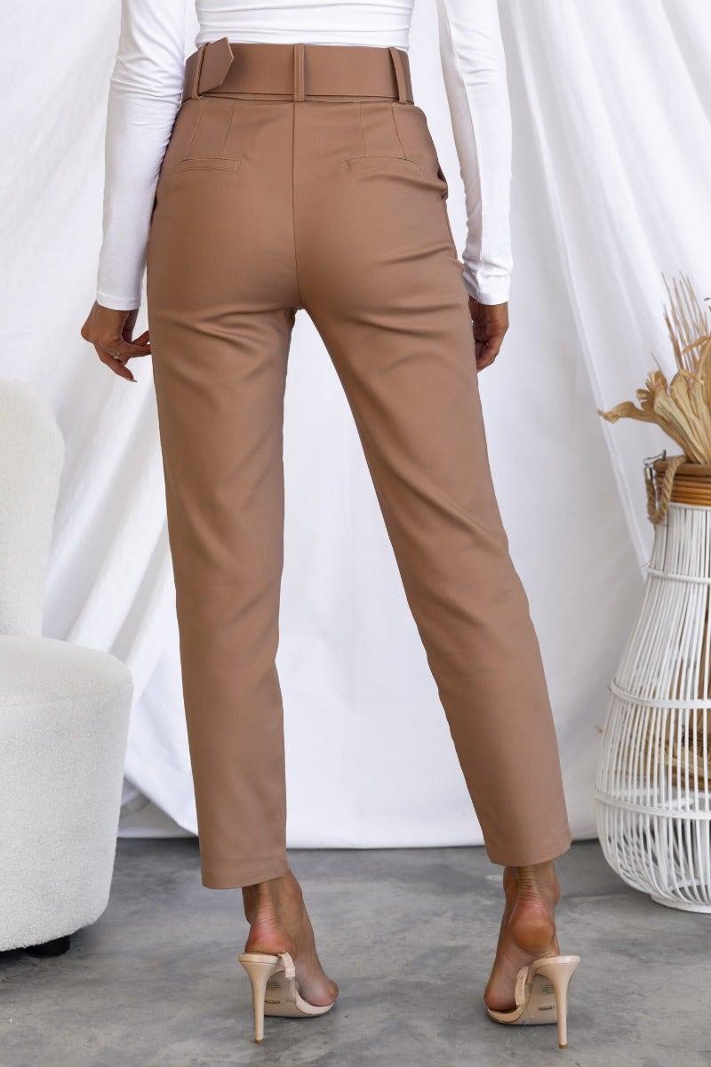 Back view of Kaniva Pants in tan with removable belt and front pockets, styled with a fitted white top.